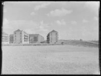 L-294 Nieuwbouw woningen aan de Haïfaweg in Hoogvliet. Rechts loopt een dijk. Op de achtergrond het dorp Hoogvliet.