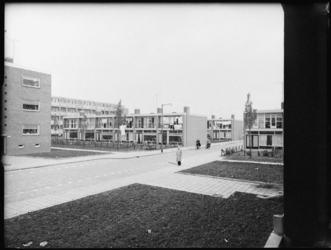 L-3012 Woningen aan de Stellendamstraat. Rondom de woonblokken groenvoorziening. Op de achtergrond flatgebouwen.
