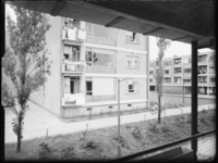 L-3013 Flatgebouwen aan de Middelharnisstraat en Dirkslandstraat. Op de voorgrond en tussen de woonblokken groenstroken ...