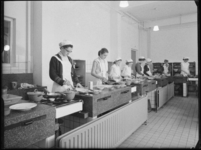 L-3117 Leerlingen van de Christelijke Huishoudschool aan de Roerdomplaan maken eten klaar in een keuken.
