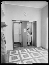 L-408 Geënsceneerde foto van een liftruimte in het Stadstimmerhuis aan het Haagseveer. De twee liftdeuren zijn geopend. ...