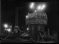 L-4101 De bouw van de Euromast bij avondlicht. Bouwbedrijf Van Eesteren werkt aan het eerste deel van de betonnen schacht.