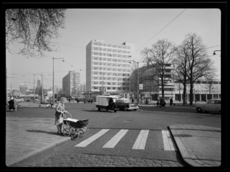 L-4155 Een dame met een kinderwagen wandelt het zebrapad op bij de kruising Westersingel, West-Kruiskade en Kruisplein.