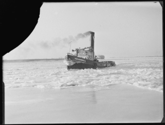 L-501 Sleepboot de Volharding 14 vaart door een met ijsschotsen bedekte rivier.