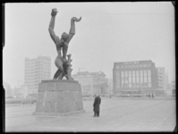 L-519 Man bekijkt het monument 'De verwoeste stad' van Ossip Zadkine op Plein 1940. Op de achtergrond van links naar ...