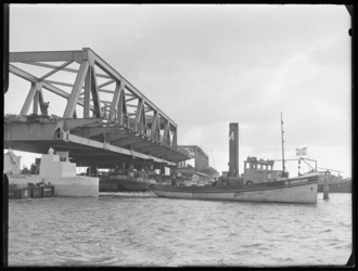 L-746 Sleepboten slepen pontons met daarop een brugdeel van de Botlekbrug. Bouwvakkers plaatsen het brugdeel op de ...
