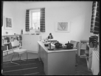 L-908 Kantoor in de Rotterdamsche Schouwburg aan de Aert van Nesstraat met een bureau waarop een lamp, asbak en twee ...