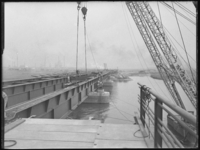 L-913 Bouwvakkers bevestigen brugdelen van de Botlekbrug die zojuist zijn geplaatst op de rivierpijlers. Op de ...