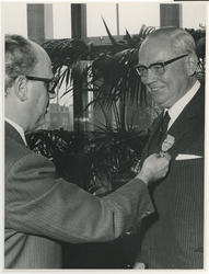 1968-1932 Afscheid van J. van Mill, die met pensioen gaat. Wethouder G.Z. de Vos (links) reikt aan de heer J. van Mill ...