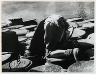 1968-290 Gedwongen door de schaarste zoekt een kind naar voedselresten in vuilnisbakken tijdens de Hongerwinter in de ...