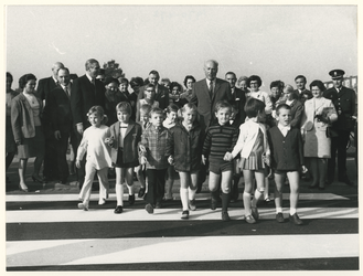 1970-472 Verkeersweek. Een rij kinderen steekt hand in hand het zebrapad over van het Slingeplein gevolgd door de ...