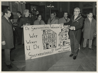 1971-72 Gastarbeiders poseren op de nieuwjaarsreceptie van Burgemeester Thomassen in het stadhuis met een bord met de ...