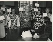 1975-2047 Dames met protestborden in het kantoor van burgemeester André van der Louw.