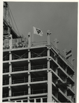 1975-2158 Het betonnen skelet van het gebouw met vlaggen.