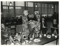 1975-247 Mevrouw G. van Deelen (links) gaat na vijfendertig jaar werkzaam te zijn geweest als caissière, bij onder ...