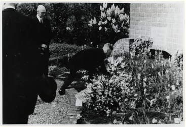 1975-467 Een man legt een krans neer bij oorlogsgraven op de begraafplaats Hofwijk van zes soldaten die zijn gesneuveld ...