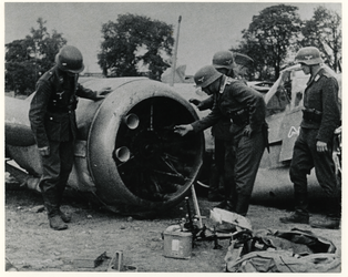 1975-485 Duitse soldaten bekijken de wrakstukken van een Engels vliegtuig dat is neergeschoten.