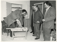 1975-584 Burgemeester André van der Louw helpt een handje in gebouw Drom, dat wordt ingericht als recreatiecentrum.