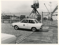 1976-1838 Een politieauto voor de poort bij het stuwadoorsbedrijf Deko-Hanno in de Basaltstraat op het 3e Katendrechtsehoofd.