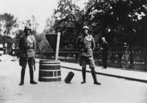 1976-1856 Twee Nederlandse soldaten bewaken de plaats waar een niet ontplofte bom uit het wegdek steekt van de Plantageweg.