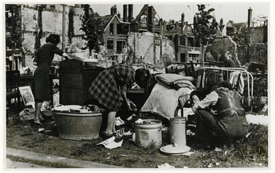 1976-1863 Op de middenberm van de Lisstraat zoeken bewoners van verwoeste huizen huisraad dat nog bruikbaar is uit.