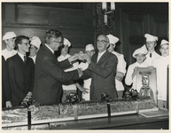 1977-2065 Burgemeester W. Thomassen (links) en wethouder J. Worst (rechts) zijn jarig. De jarigen overhandigen elkaar ...