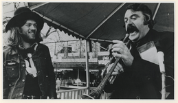 1977-2268 Burgermeester André van der Louw hanteert een trompet.
