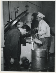 1977-3052 Het personeel van de centrale keuken schept het voedsel in gamellen. De gaarkeukens werden gebouwd om de ...
