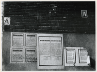 1977-3076 Muur met aanplakbiljetten van de Duitse bezetter met daarop bekendmakingen (Bekanntmachungen) die tijdens de ...