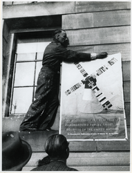 1977-3146 Het eerste naoorlogse affiche wordt opgehangen.