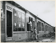 1977-3214 Glazenzetters aan het werk bij noodwinkels aan de Statenweg.