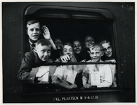 1977-3281 Kinderuitzending van het station Delftse Poort naar de Oostmark in Oostenrijk. Kinderen wuiven vanuit de ...