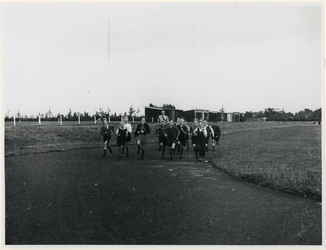 1977-3287 Een groepje jongens en een begeleider lopen hard op een atletiekbaan tijdens de Tweede Wereldoorlog.