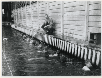 1977-3291 Kinderen met banden van kurk om krijgen zwemles tijdens de Tweede Wereldoorlog.