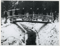 1977-3370 Arbeiders in het gelid over een houten brug in een werkkamp, georganiseerd door de Nederlandsche ...