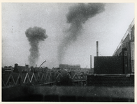 1977-3518 In de achtergrond rookpluimen van de ontploffingen in de haven.