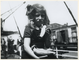 1977-3823 Een meisje met een banaan van het Noorse schip Duale die bananen vervoerd met bestemming Zwitserland, na de ...