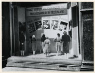1977-3861 Een winkeletalage met het opschrift: Vraagt binnen inlichtingen over vrouwenarbeid in Nederland. Vele wegen ...