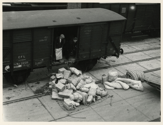 1977-3929 Buitenlandse hulpgoederen bestemd voor slachtoffers van de watersnoodramp worden uit een een wagon geladen.
