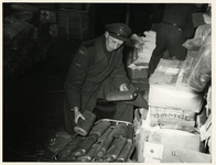 1977-3952 Een beambte van de douane controleert hulpgoederen (kruiken en en sigaretten), bestemd voor de slachtoffers ...