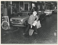 1979-2069 Op de Vlietlaan probeert een dame zich met een paraplu op de been te houden.