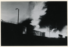 1979-2279 Grote zwarte rookwolken stijgen op na een bombardement op een olieopslagplaats bij de 1e Petroleumhaven.