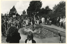 1982-291 Kinderen lopen over een evenwichtsbalk boven een grote bak met water.