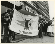 1983-736 Bejaardverzorgster Marion Beekhuis assisteert bij het hijsen van de door haar ontworpen nieuwe vlag aan de ...
