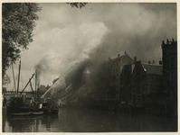 1985-870 Brandweerlieden blussen de brand aan de Boompjes middels een drijvende brandspuit in de Scheepmakershaven.