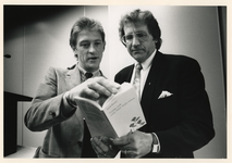 1989-3360 In het Inntel Hotel overhandigt wielrenner Gerrie Kneteman aan Lee Towers het boekje 'Vraag ook eens naar ...