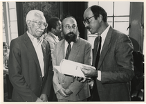 1989-3389 Samen met de heren W. Telgt (links) en J. Sanders (midden) bekijkt wethouder H.J. Simons de handleiding ter ...