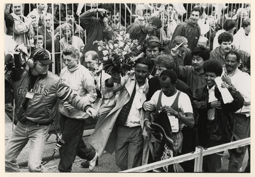 1989-3397 Omringd door de pers en coaches verlaat marathonloper Belayneh Densimo het parcours op de Coolsingel.