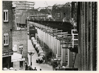 1989-829 Gezicht op het spoorwegviaduct bij de Hoogstraat met een trein die in zuidelijke richting rijdt. Op de ...