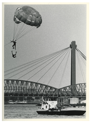 1991-3185 Tijdens het roei-evenement Regatta hangen twee parachutisten aan een door een motorboot voortgetrokken parachute.